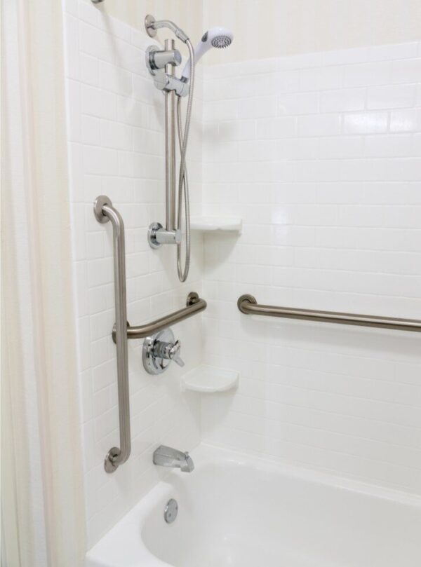 Curbless walk-in shower with modern grab bars and bench in aging-in-place bathroom