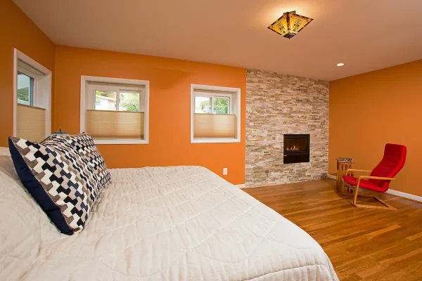 bedroom with orange walls and fireplace