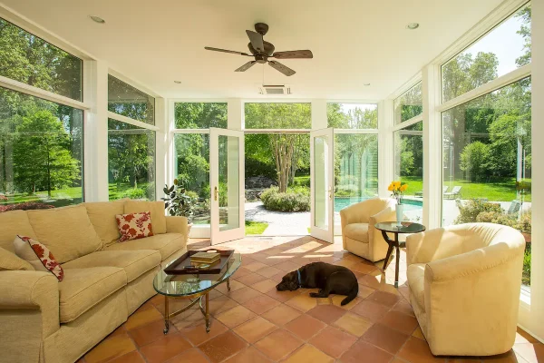 sunroom with chairs by pool with pet