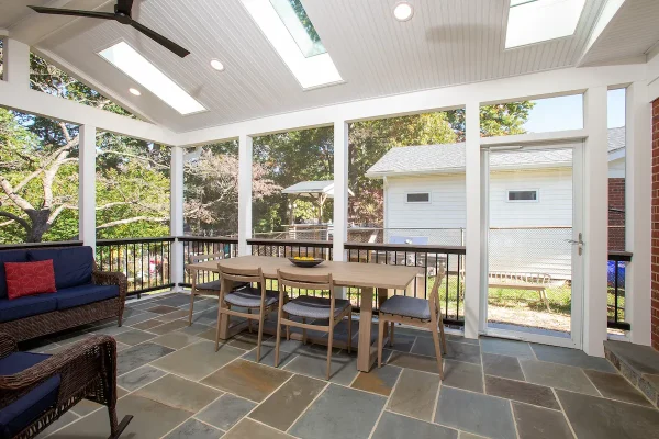 screened porch with tables and chair